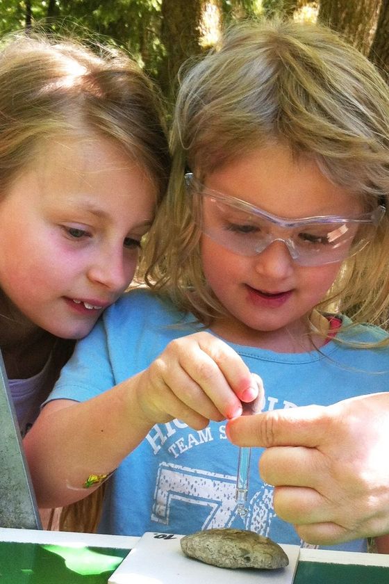 Zwei Mädchen lassen im Rahmen einer Geo-Rallye Säure auf einen Stein tropfen.